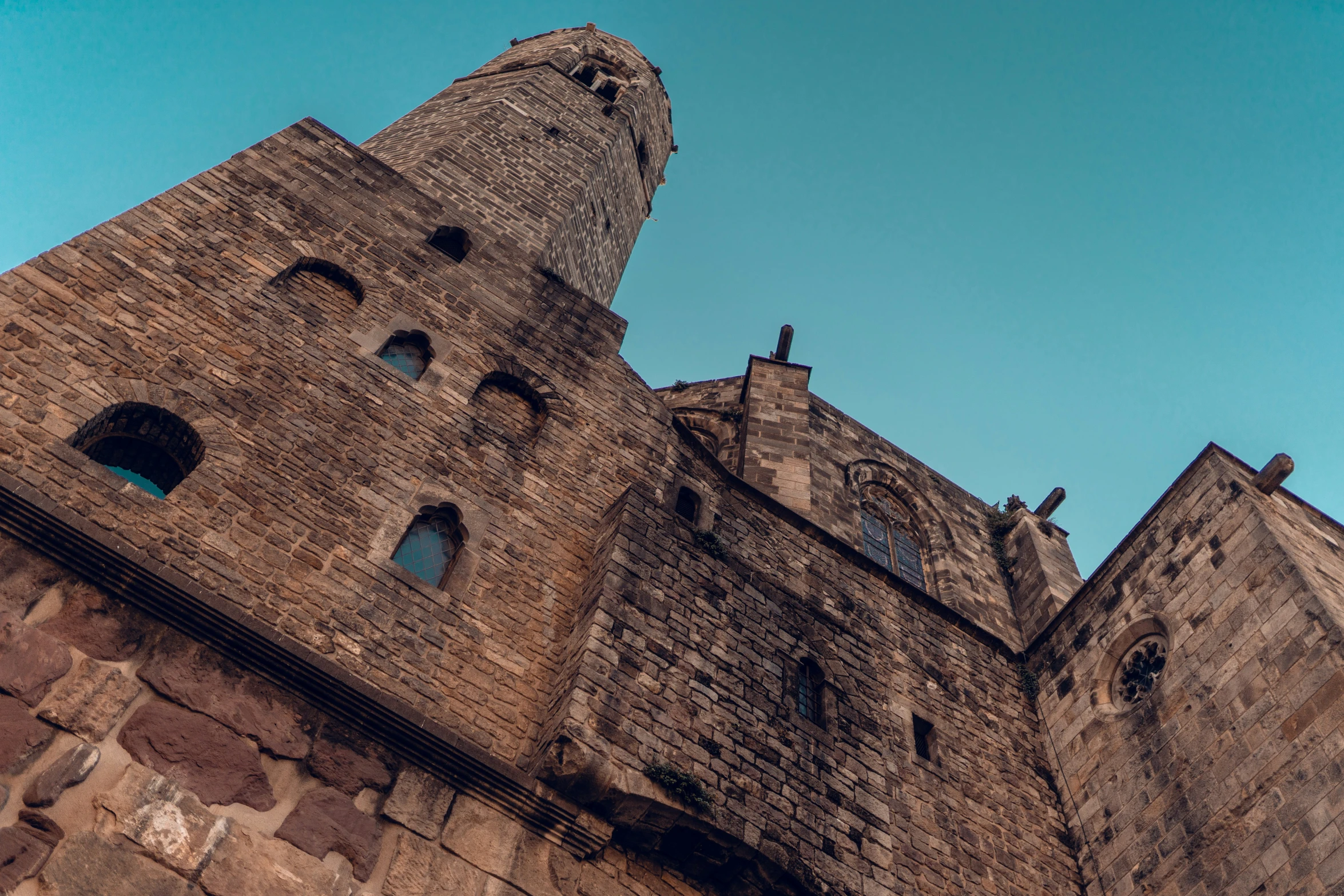 the top of an old brick castle against a blue sky