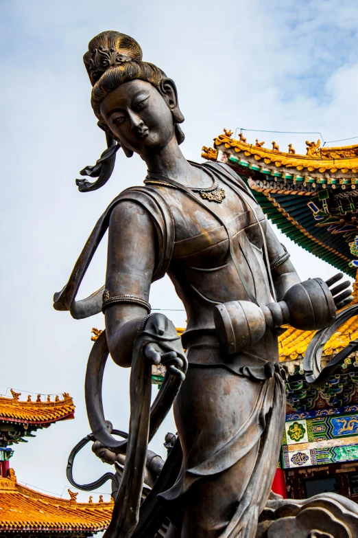 a statue of a person holding a vase with several asian writing on it