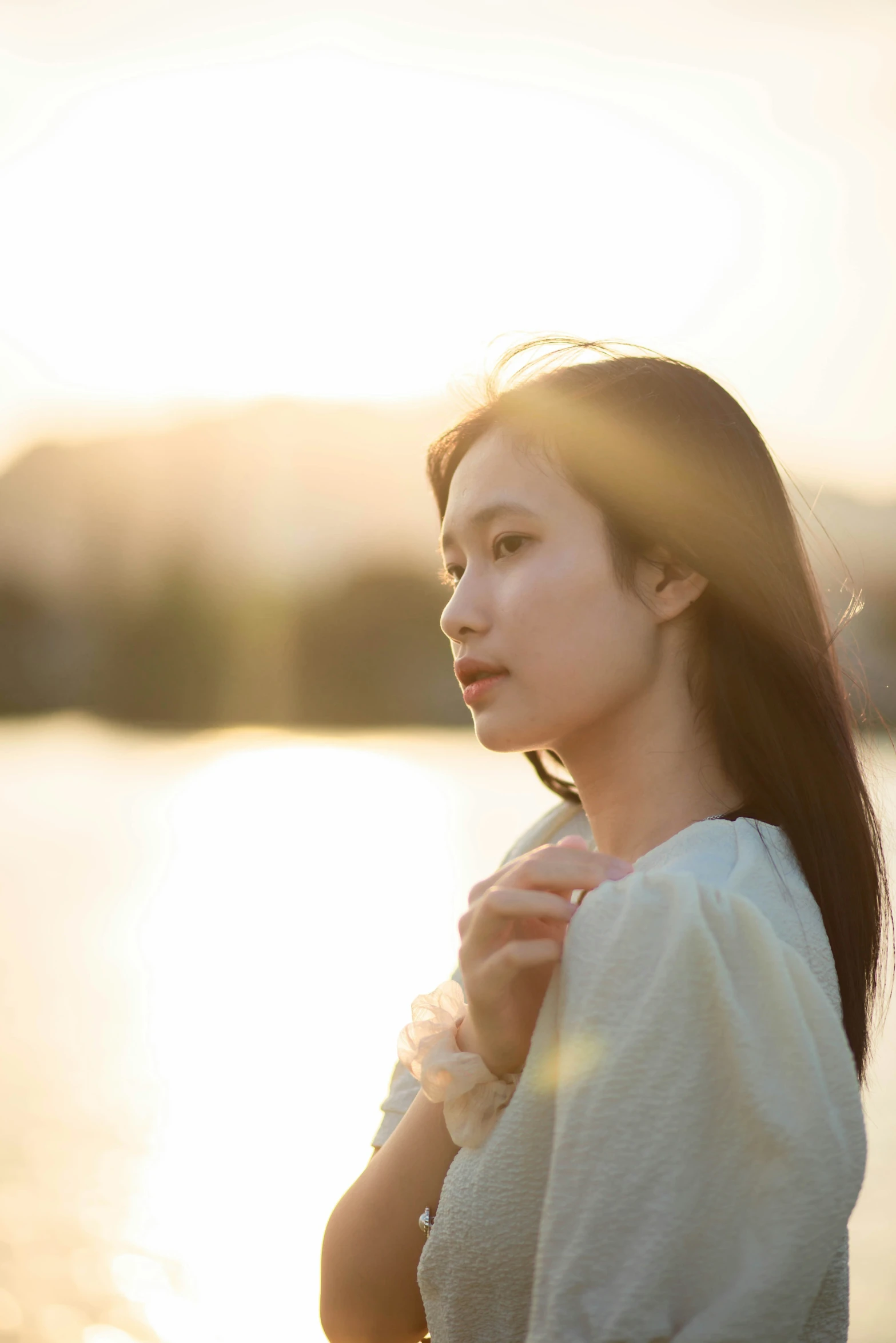 a woman is standing by the water and wearing a robe