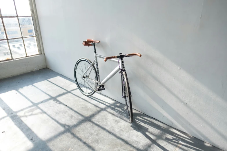 a bicycle parked in an empty room beside a window