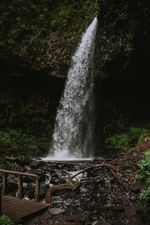 the bottom of a waterfall surrounded by rocks