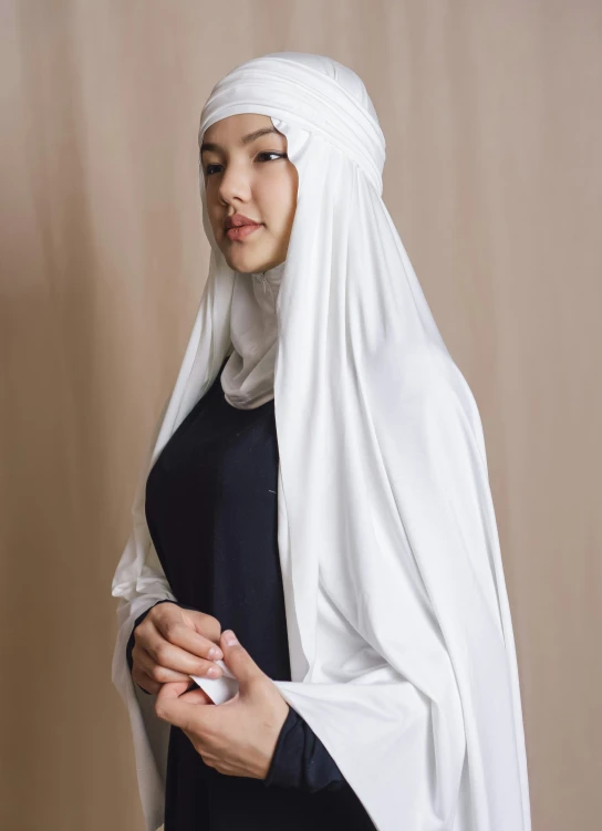 a woman wearing a white head covering and black dress