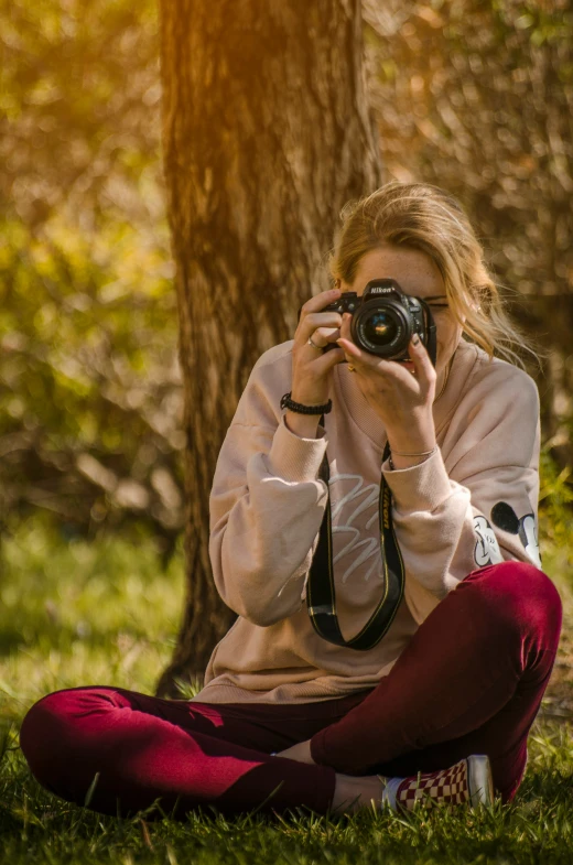 the woman sits under a tree and takes a po