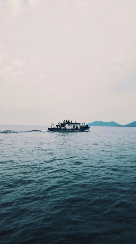 a large boat in the water with hills in the distance