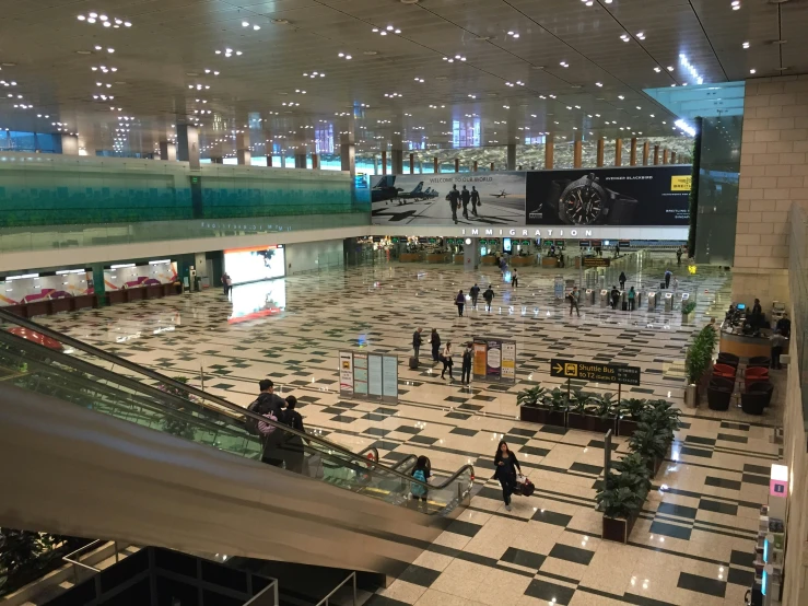 a busy airport lobby with several people walking through it