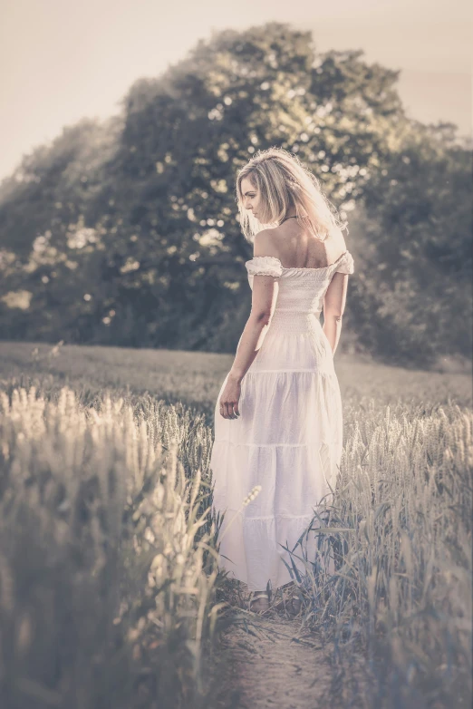 woman standing in the middle of grass with her dress open