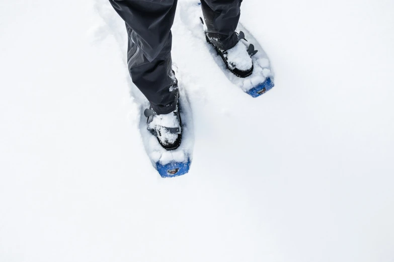 a person wearing snowshoes in the snow and with a shoe