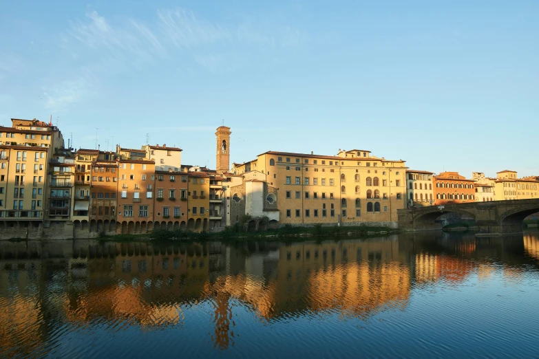 the old city houses are reflected in the river