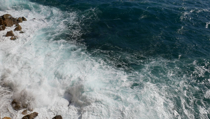 water sprays onto the rocks in front of the shore