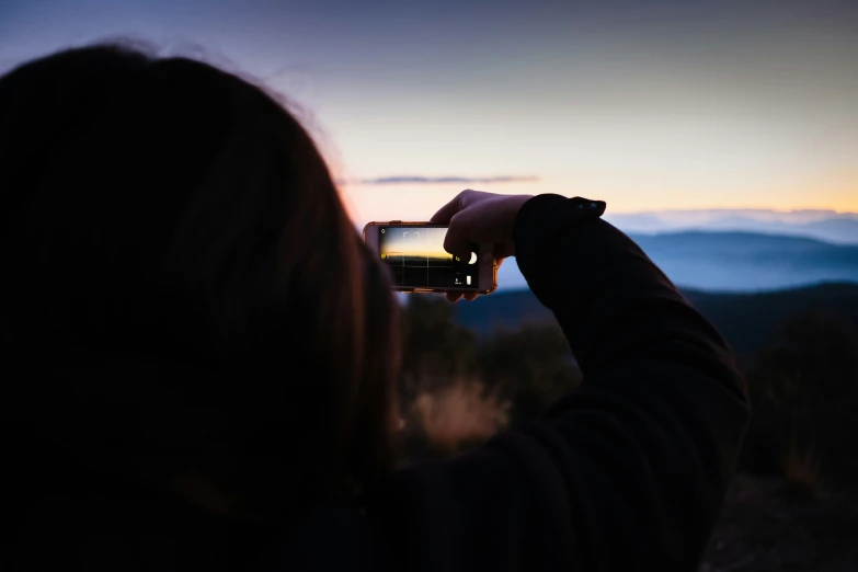 someone holding up their camera in the night sky