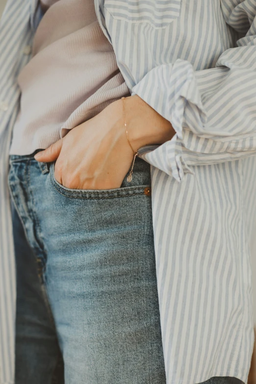 a woman wearing an open - back striped shirt and jean jeans