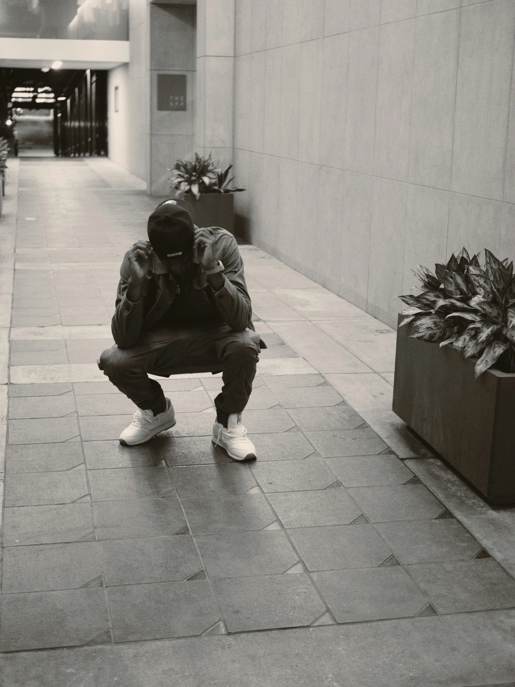 person leaning against a wall holding onto the ground