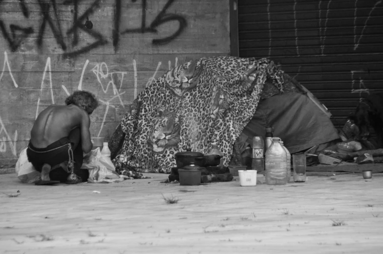 a woman squatting down outside with a tarp over her face