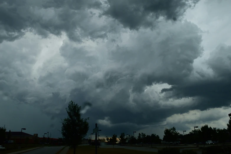 a street sign sits in the foreground under dark clouds