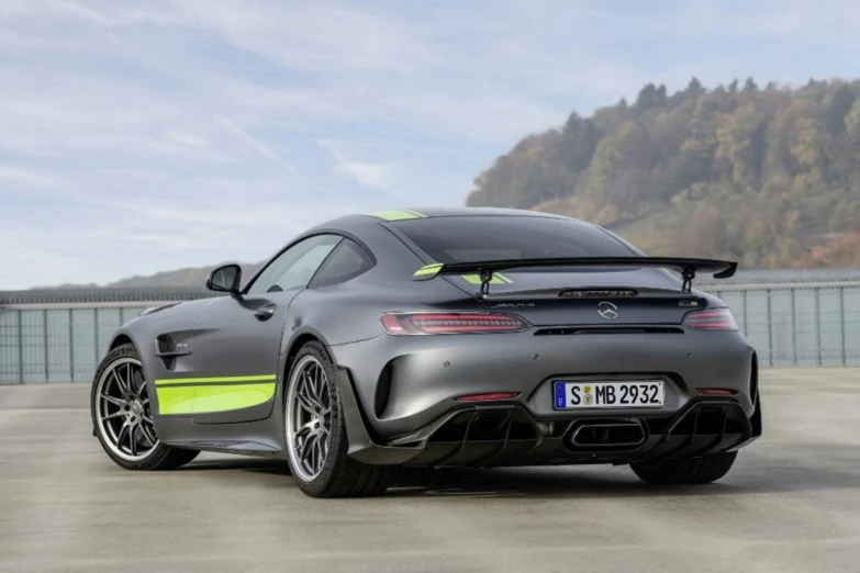 a sports car sits parked on a gravel parking lot