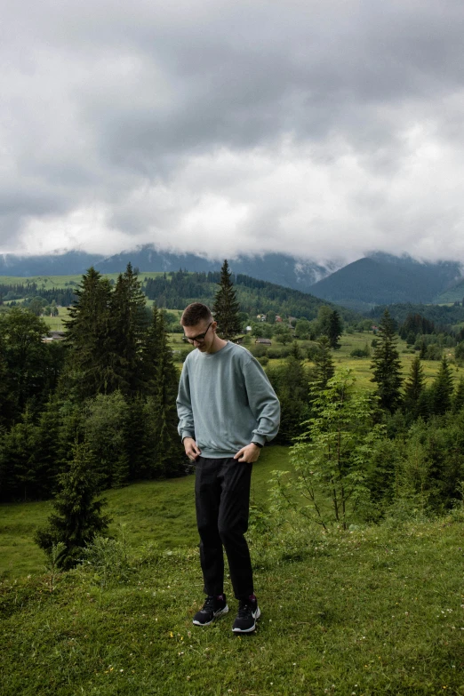 a man standing in the grass looking over