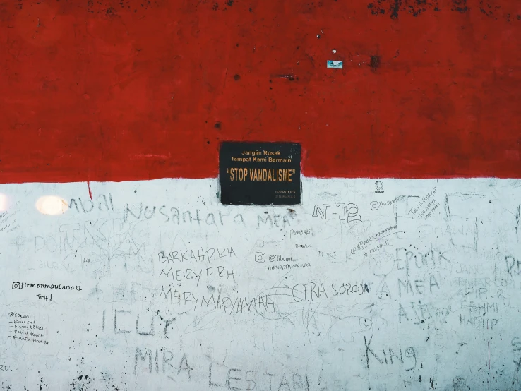 a wall with a sign written on it that reads