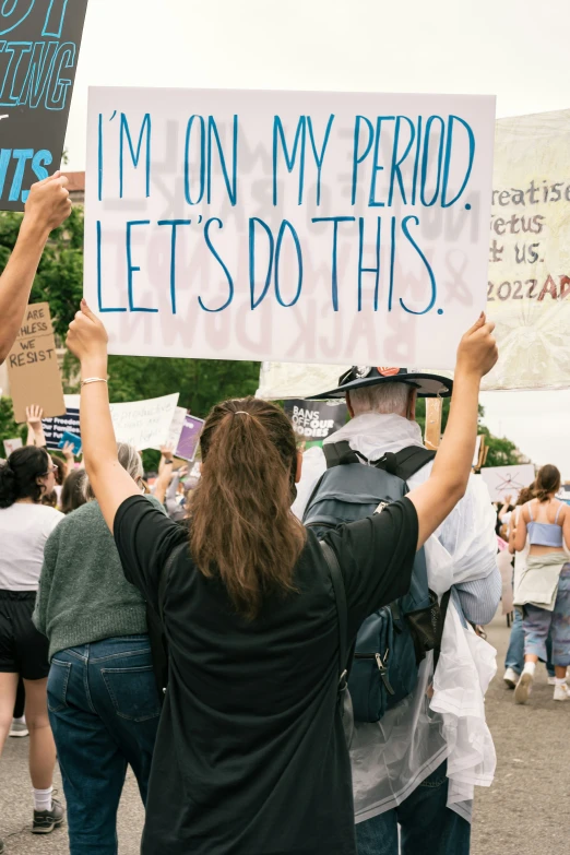 people holding up signs in front of a crowd