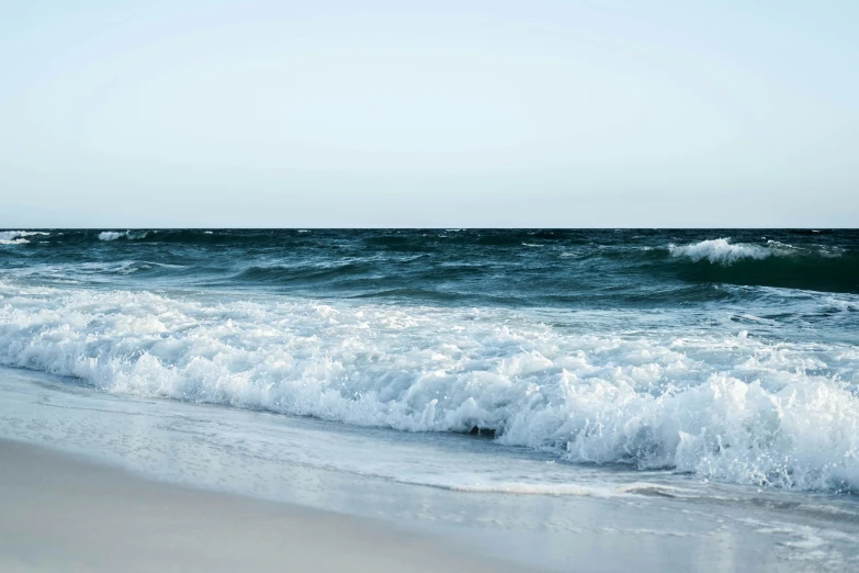 a beach scene with waves crashing on the sand