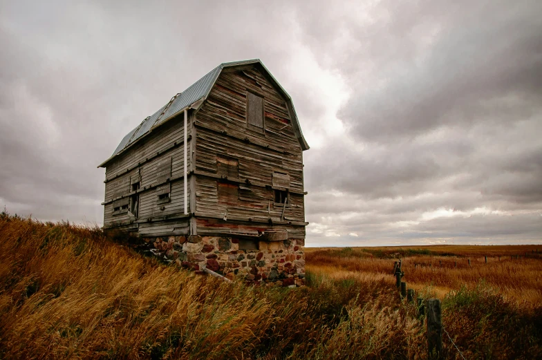 an old wooden building sitting on top of a lush green hillside