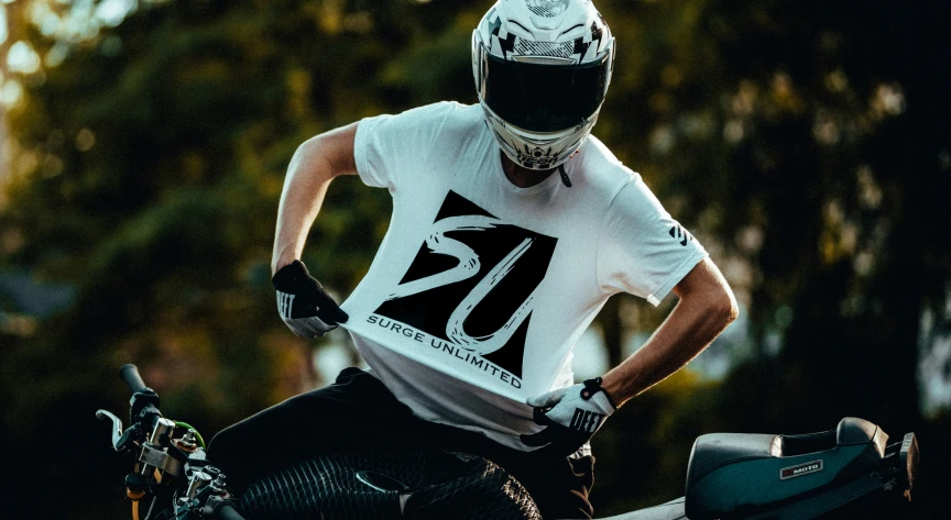 a motorcyclist poses in his helmet while wearing his gear