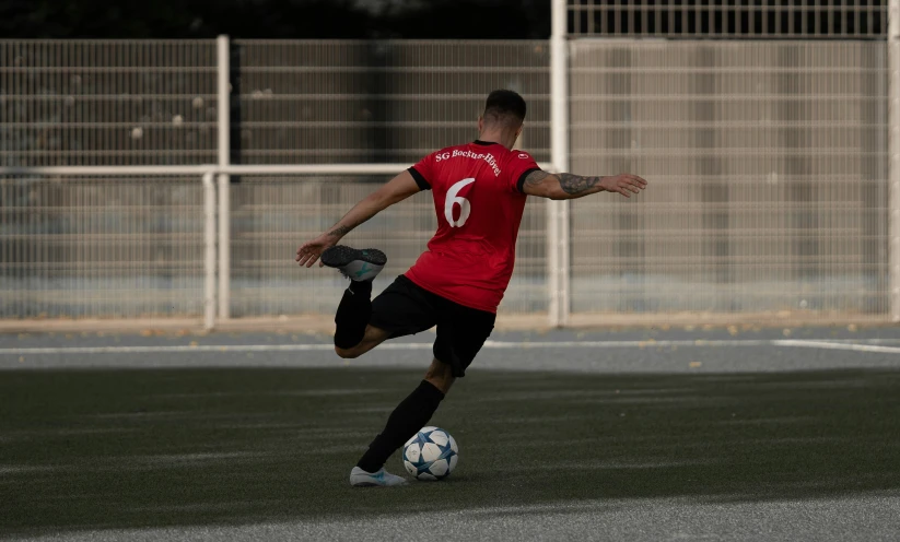 a man standing on a soccer field kicking a ball