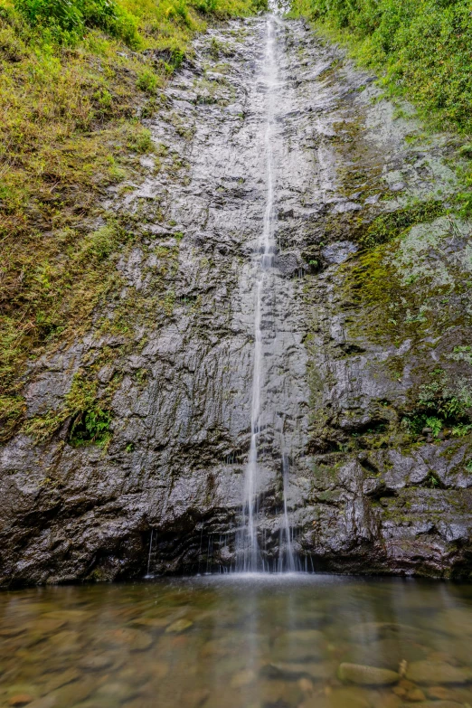 an image of a waterfall at the end of a narrow cliff