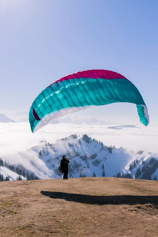 man flying a large green kite in the air