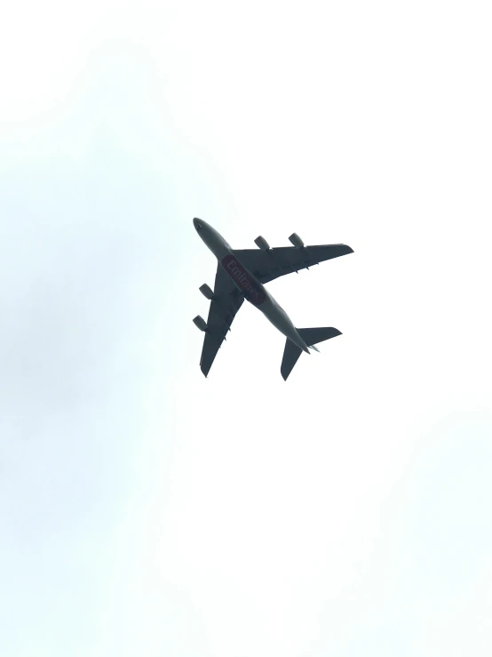 a large airplane in the sky above a tree