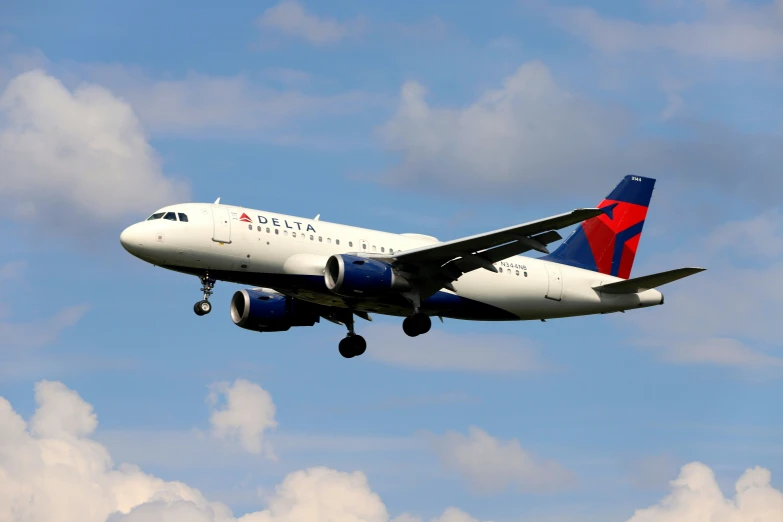 an airplane with landing gear down flies through the air