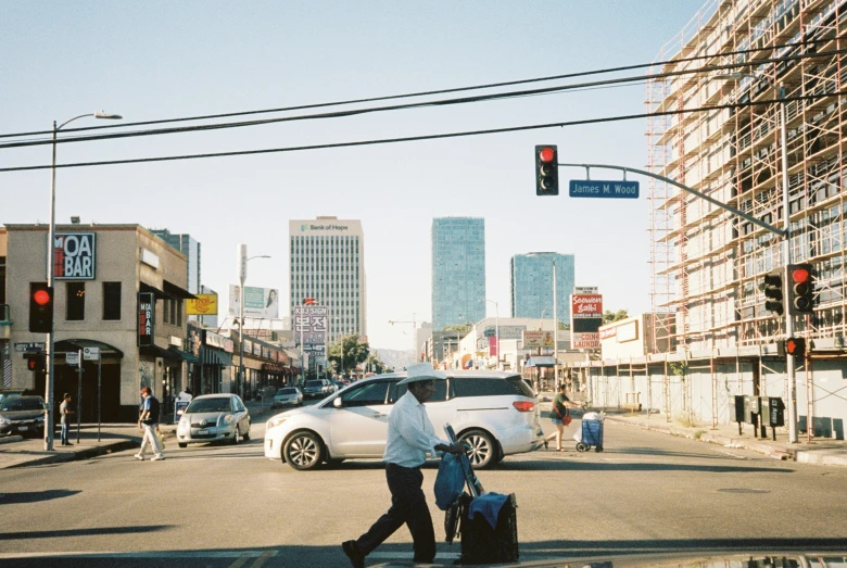 two people are walking across the street