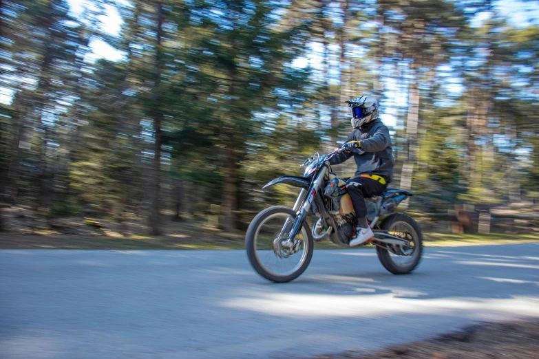 a dirt bike rider is riding down the road