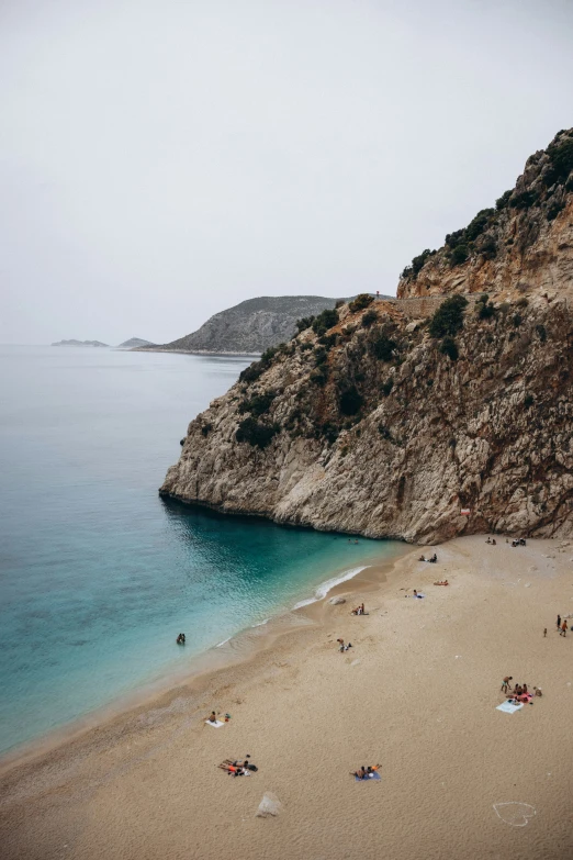 a beach with people sitting on the sand