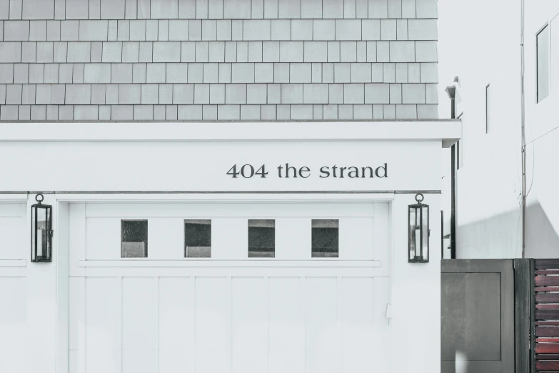 a large white garage door with a brick wall