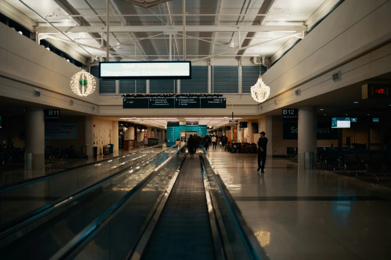 people are walking down the escalator towards the sign