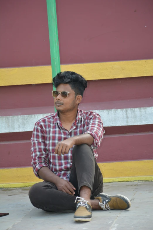 a person sitting on the ground on his knees with a book