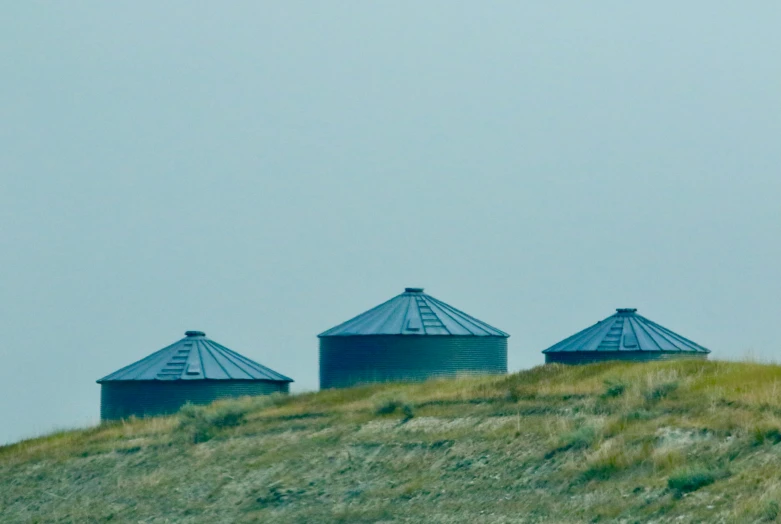 three water tanks on top of a hill