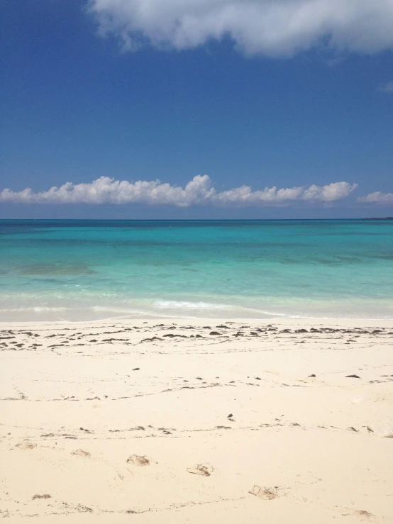 an empty beach with sand and blue water