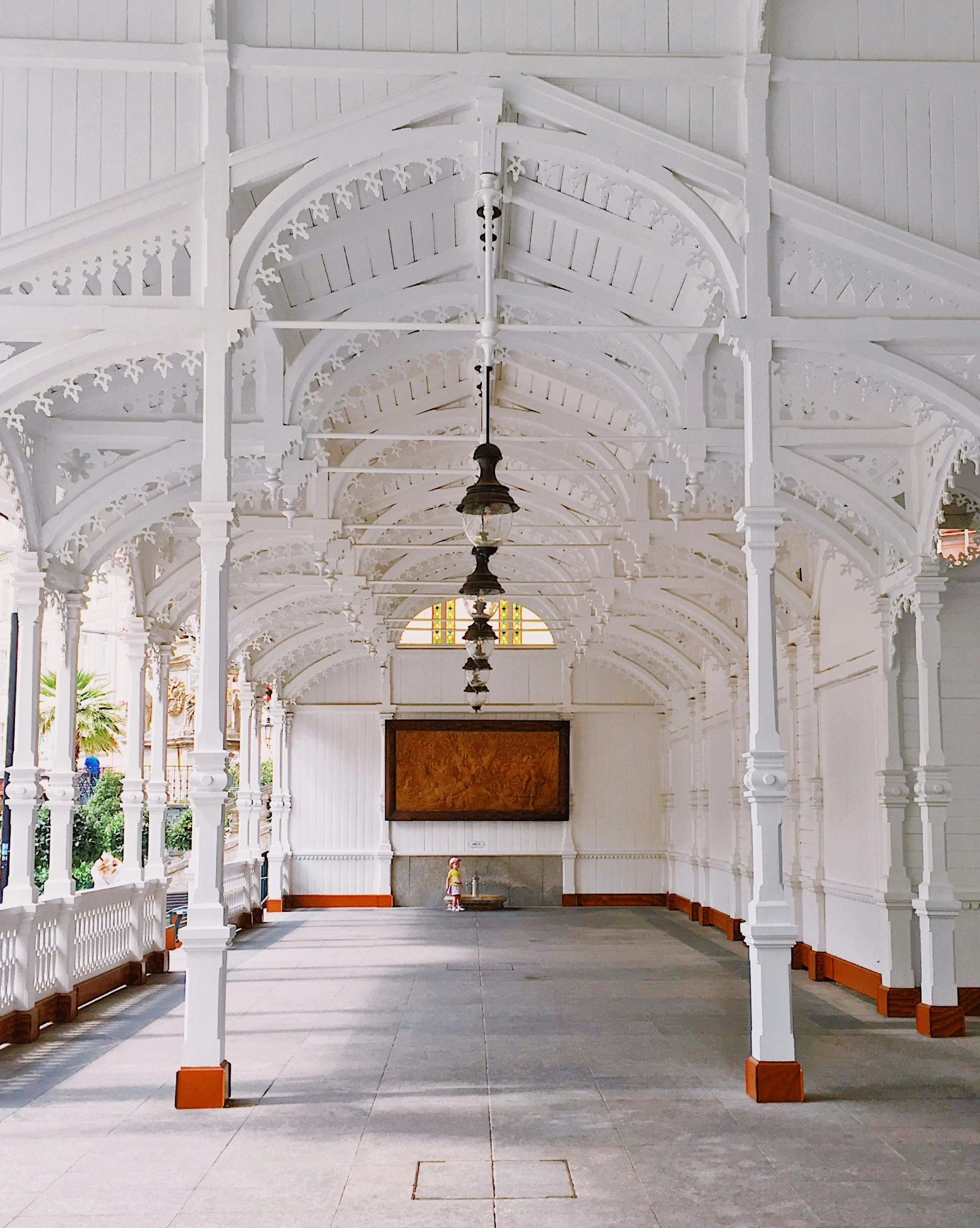 a white chapel with columns and a stained glass window