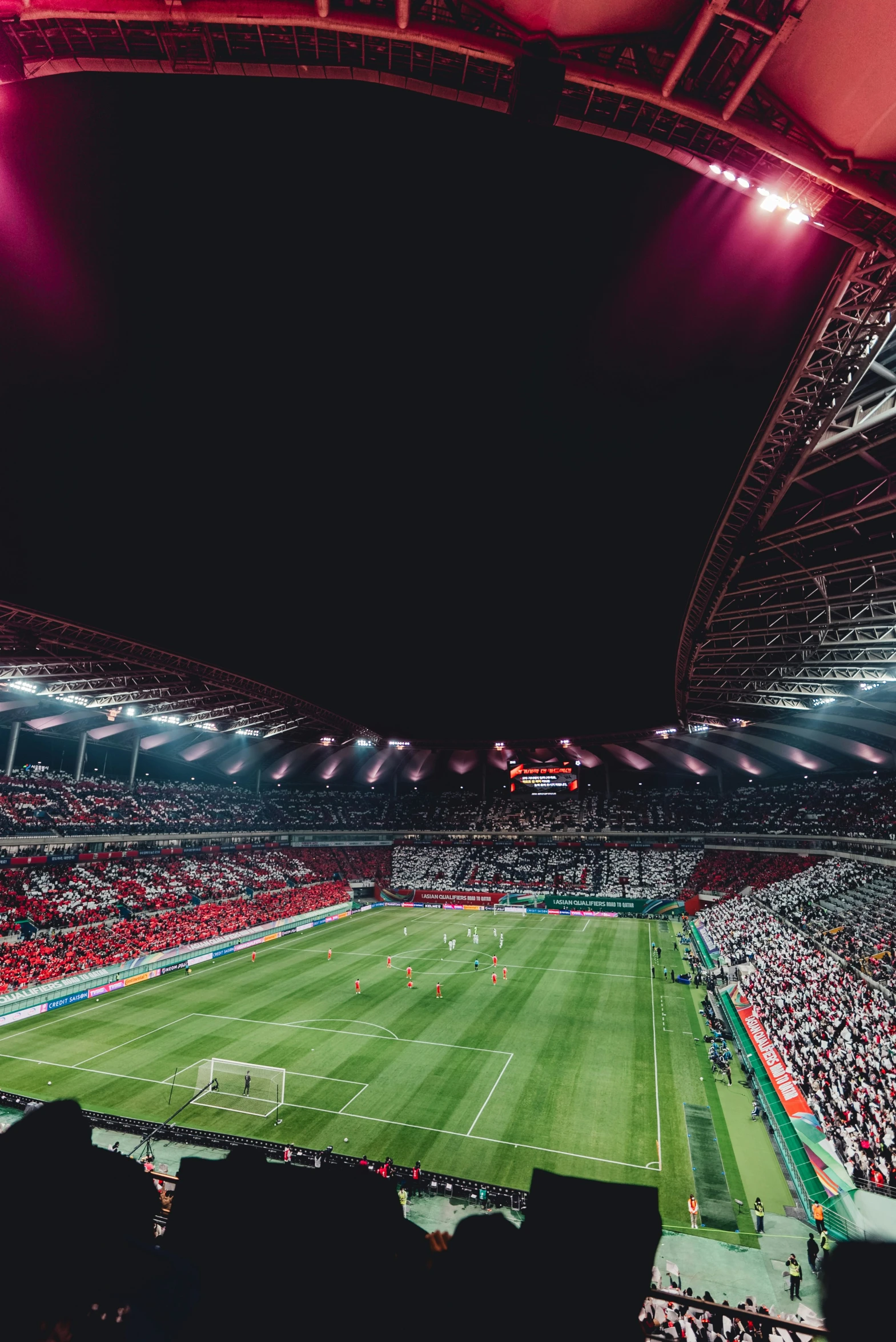 large stadium with many fans watching a soccer match