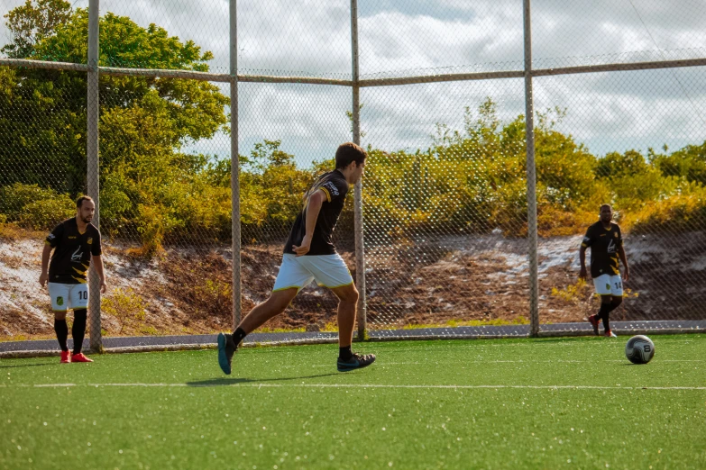 a man kicking a soccer ball across an open field