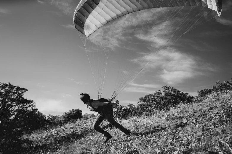 a black and white po shows a man flying his parachute