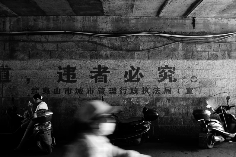 the view of several people riding motorcycles in front of a wall