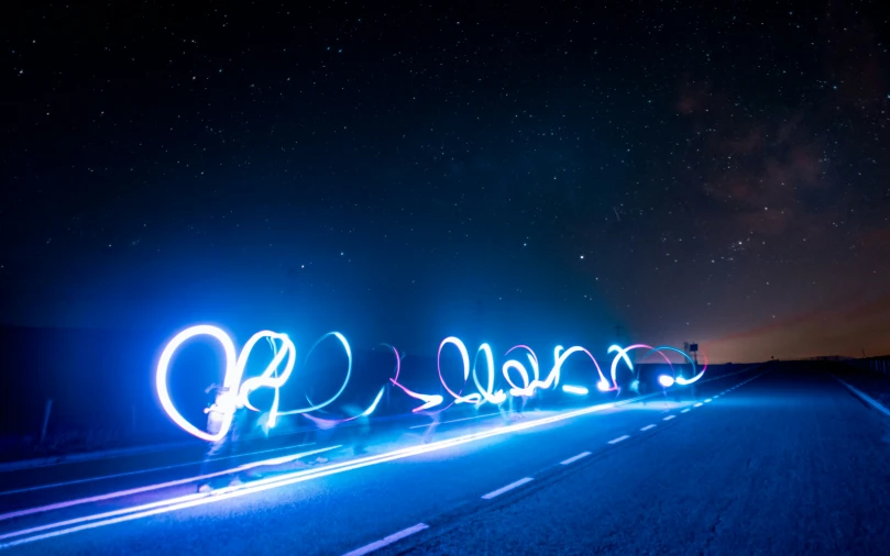 a long line of light painted letters are shown on a road