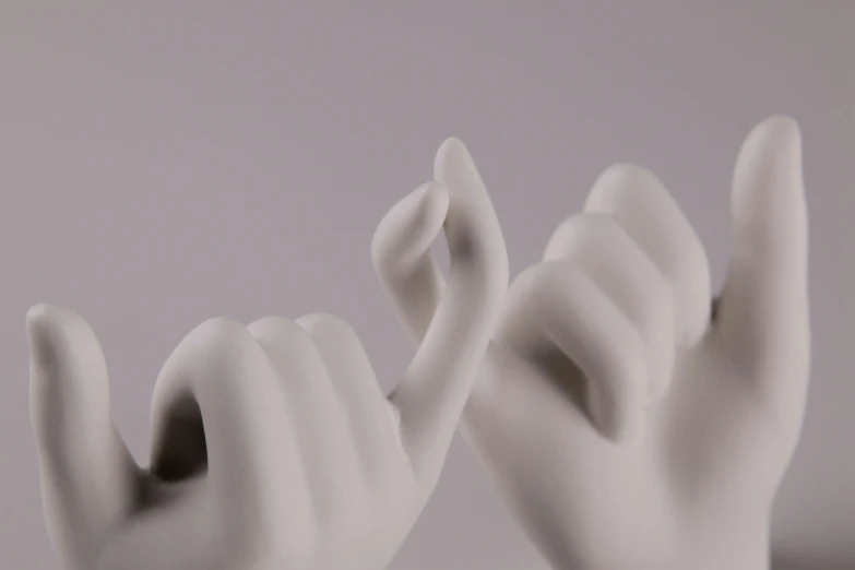 white sculptures with two hands sticking out