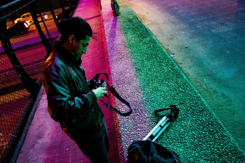 a man standing on the sidewalk, holding an umbrella