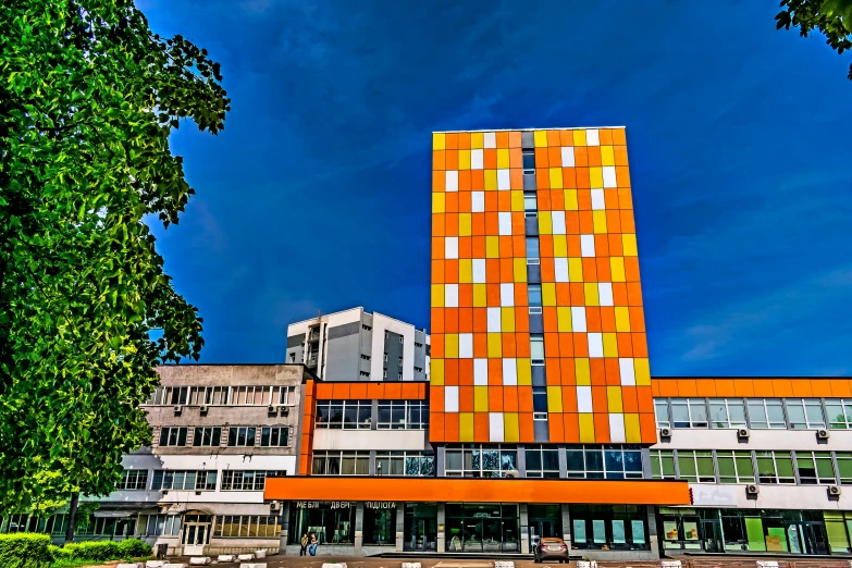 a building with yellow and white squares near trees