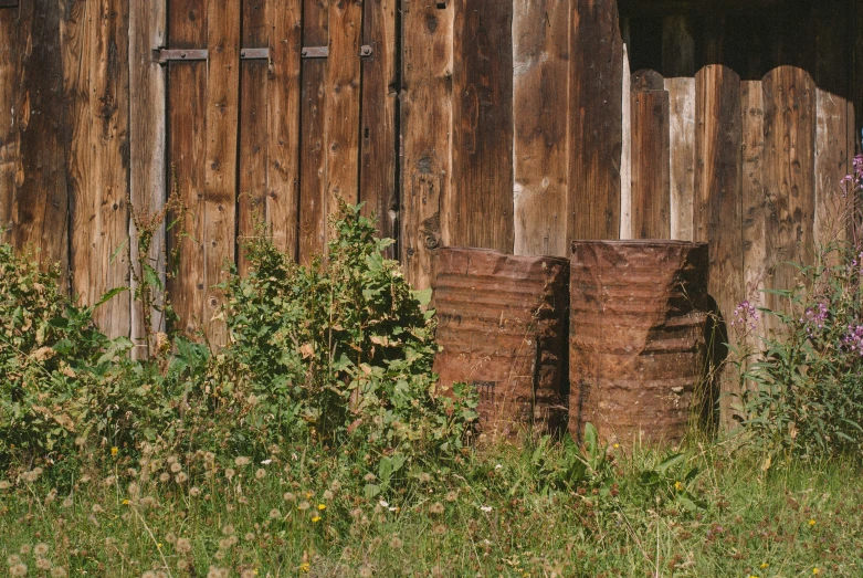 old wooden fences and rusted barrels set against it