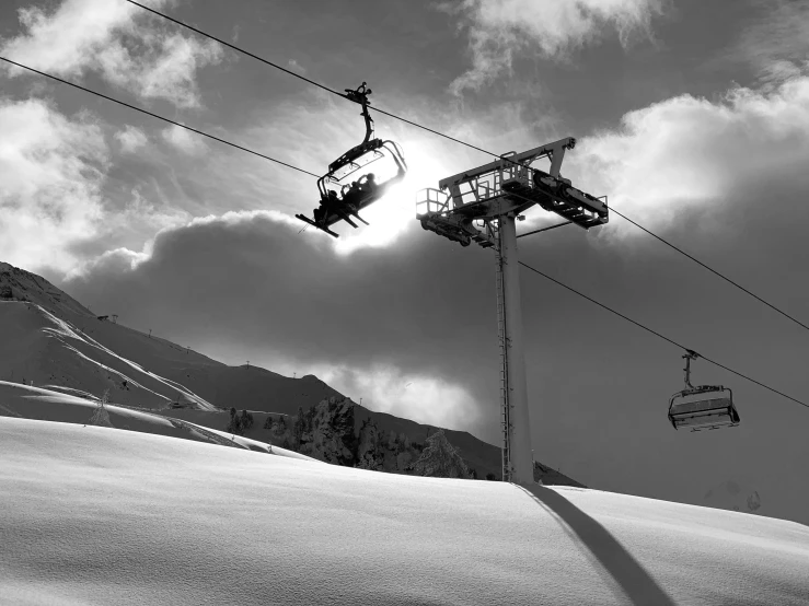 two snow - covered mountains with ski lifts on them