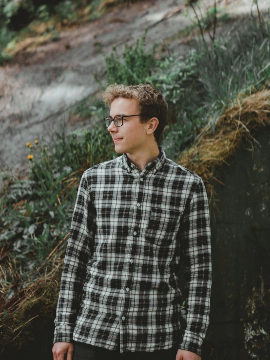 a man standing on a path near bushes